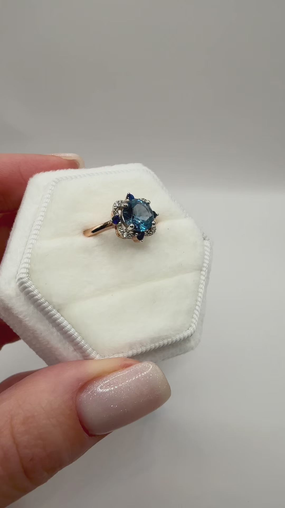 The Marina Bloom gold-plated silver ring is inlaid a round blue lab-grown sapphire